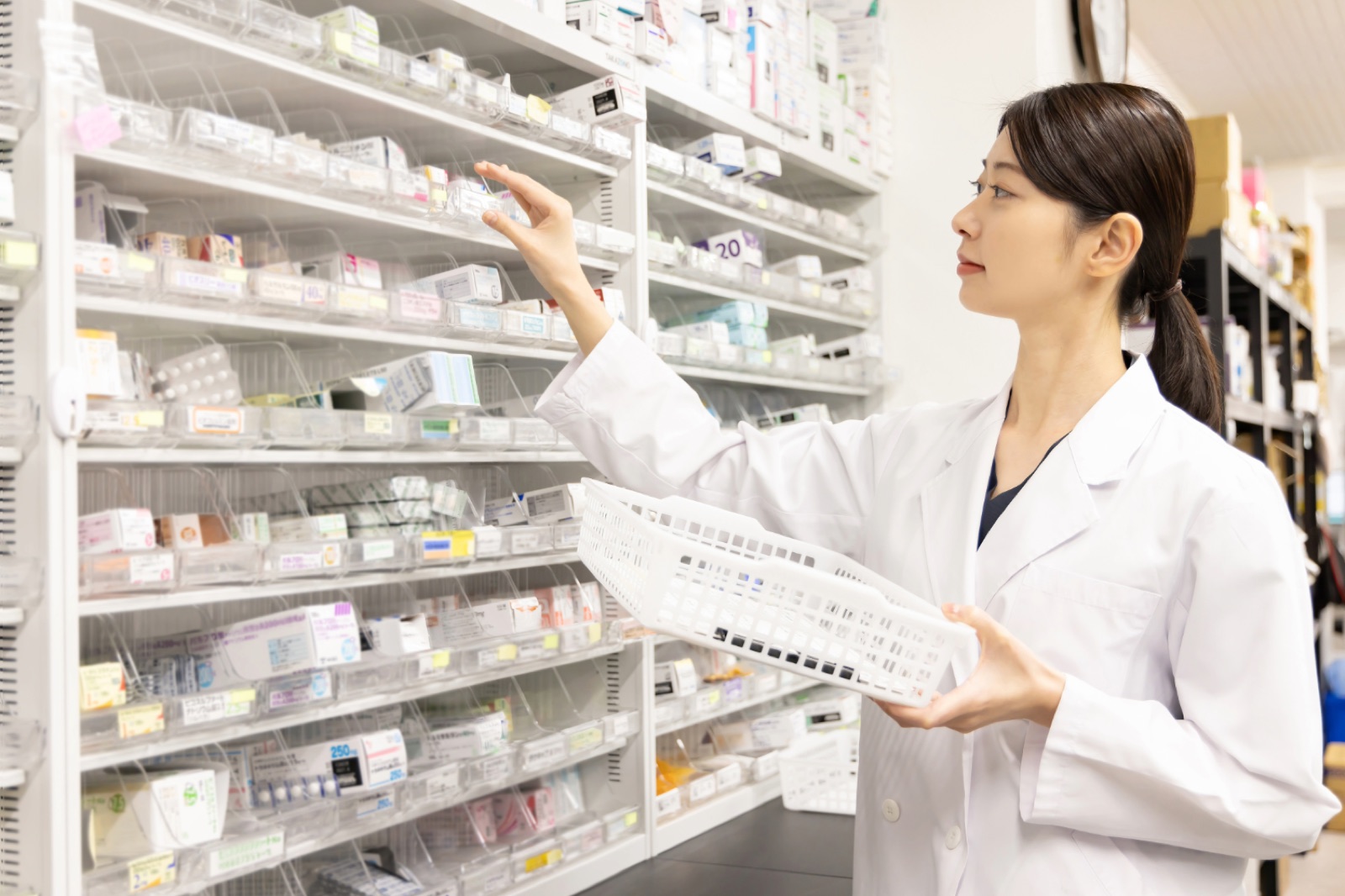 調剤棚から薬を取り出す薬局の薬剤師